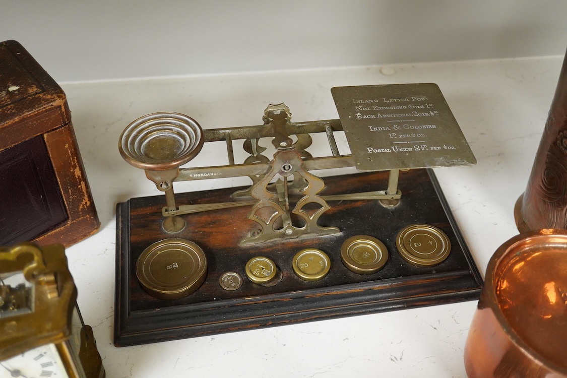 A collection of items to include a leather cased gilt brass French carriage clock, a German bronze Jugendstil inkwell, a late 19th century ink brass inkwell, a set of postal scales with weights, a Temple & Crook small co